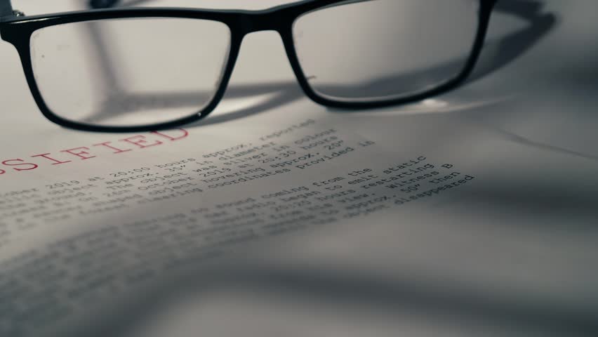 Classified Top secret document with pair of glasses close up zoom dolly selective focus