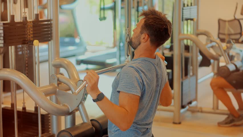 Multi-gym Workout. Chest Workout Push Down Biceps Curls. Indoor Bodybuilding Lifting Weight. Fitness Exercising In Sport Gym. Man Weight Lifted Exercising In Gym Cable Pushdown. Sport Club Training Royalty-Free Stock Footage #3443713383