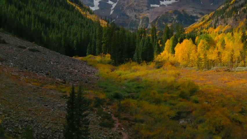 Maroon Bells Pyramid Peak Aspen Snowmass Colorado wilderness Incredible stunning cinematic aerial drone fall autumn colors snow covered Rocky Mountains peaks morning pan up slow reveal forward upward