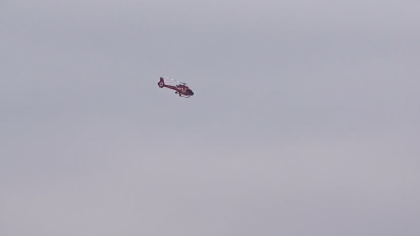 Helicopter flying in distance silhouette shot dull smog day