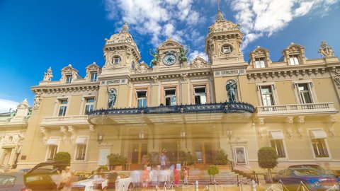 Front view of Grand Casino in Monte Carlo timelapse hyperlapse, Monaco. historical building. Parking in front of entrance. Palms on the side. Blue cloudy sky at summer day