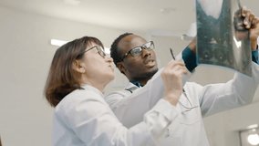 Medical team in lab coats examining x-ray image. Slow motion - Powered by Shutterstock - Get 15% off with code: PIKWIZARD15