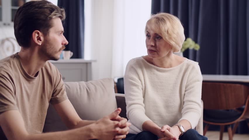 Mature mother screaming and swearing at her adult son man. Jobless adult young man listening his mums swear. Mum gives advices to her stupid son. Not okay relationships Royalty-Free Stock Footage #3443767615