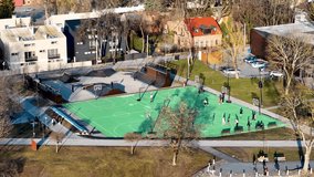 Aerial 4K footage of public basketball court and skate park. Tops down aerial view video with basketball players and skaters in it in Kaunas, Lithuania