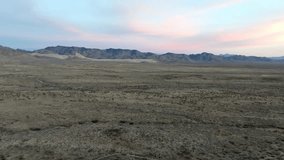 Arizona desert landscape with mountains in the distance and drone video moving in.