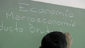 Teacher Writing "Economy, Macroeconomics and Gross Domestic Product" during an Economics Class At An Argentine School. Close Up.   - Powered by Shutterstock - Get 15% off with code: PIKWIZARD15