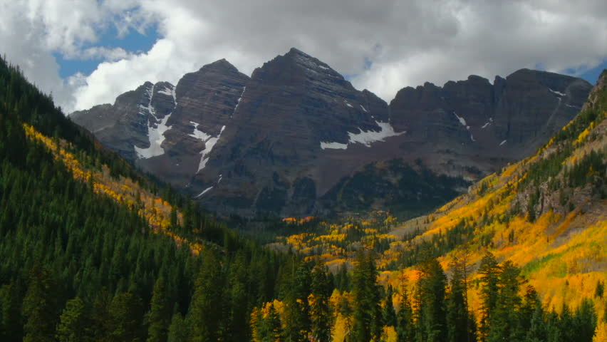 Maroon Bells Pyramid Peak Aspen Snowmass Colorado wilderness Incredible stunning cinematic aerial drone fall autumn colors snow covered Rocky Mountains peaks morning backward motion