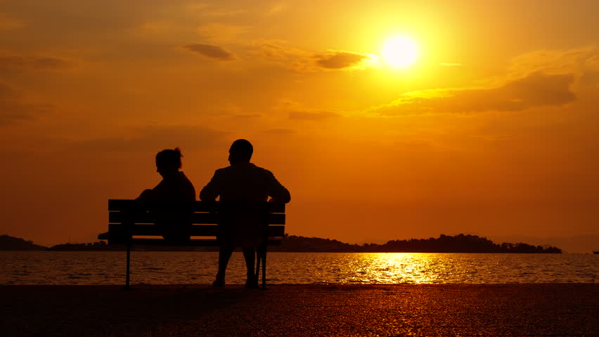Unhappy couple on evening shore. An unhappy couple silhouette on bench during evening time. A concept of problems in family during summer trip. Royalty-Free Stock Footage #3443934125