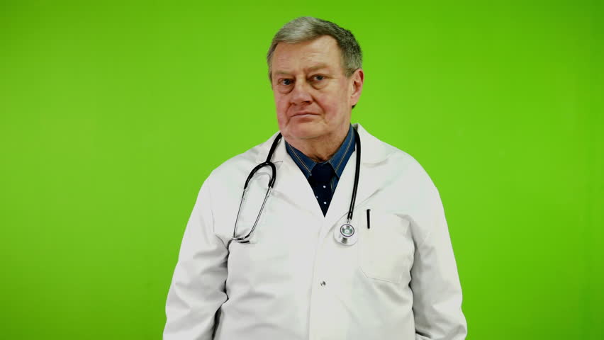 Disgruntled doctor in white coat says no, sign disapproval looking at camera. Mature medic showing denying, rejecting, disagree. Green screen, chroma key. Royalty-Free Stock Footage #3443939117