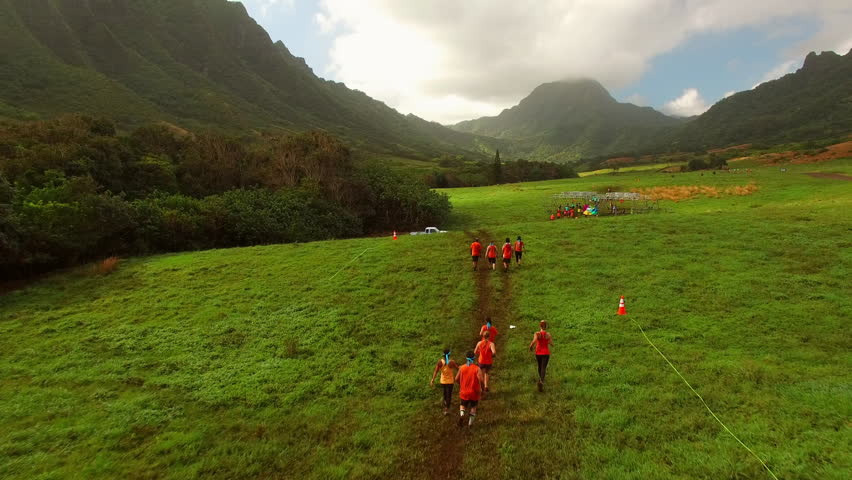 Aerial: Drone Forward Shot Of Men And Female Athletes Running Marathon On Oahu Island Under Cloudy Sky - Honolulu, Hawaii