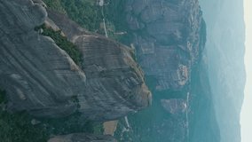 Vertical video. Meteora, Kalabaka, Greece. Meteora - rocks, up to 600 meters high. There are 6 active Greek Orthodox monasteries listed on the UNESCO list, Aerial View