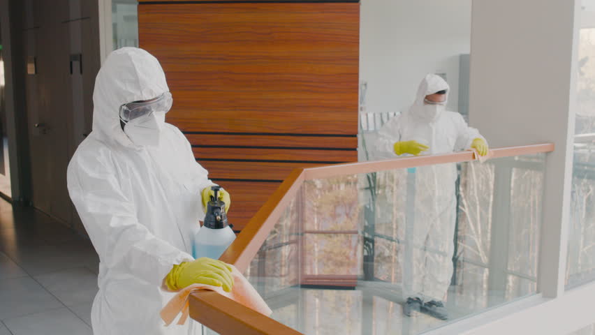 Two Cleaning Men Wearing Personal Protective Equipment Cleaning Stair Railings Inside An Office Building Royalty-Free Stock Footage #3444132581