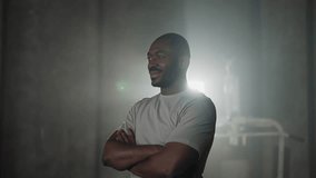 African american sportsman in gym. Man in white t-shirt smiling standing in close pose with hands crossed on chest ready for sport training. Healthy lifestyle, confident habits, sportive body concept. - Powered by Shutterstock - Get 15% off with code: PIKWIZARD15