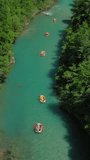 Aerial top view of rafting boats on turquoise mountain river. Vertical video