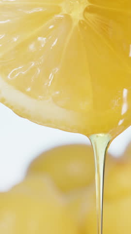 Honey with a mint leaf flows down a slice of Lemon. Close-up. Vertical video Social Media