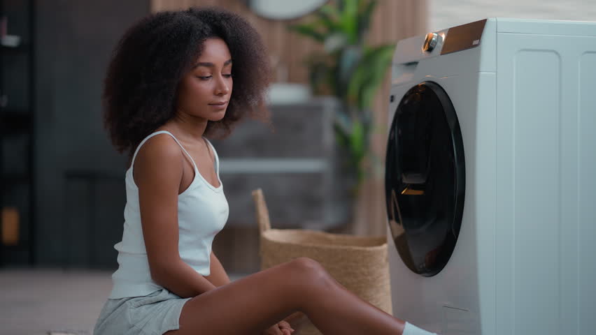 African American woman ethnic girl biracial female housewife householder with laundry open washing machine take white clean towel cloth smelling good smell enjoy soft clothing conditioner hug cuddling Royalty-Free Stock Footage #3444240293