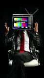 mr tv head man seated with a television as a head in vertical format