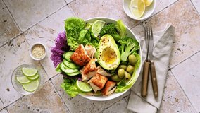 Salad bowl of salmon, avocado, broccoli, olives and fresh Romaine lettuce. Poke bowl salad, stock footage video 4K