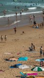 timelapse of a crowded beach, playa de liencres, in galicia, spain in the summer in vertical