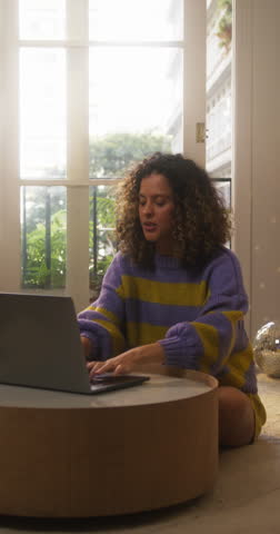 Vertical Screen: Portrait of Smiling Young Woman Working from Home on Laptop Computer in Sunny Cozy Apartment. Successful Creative Female Entrepreneur Does Remote Job for e-Business Project Online Royalty-Free Stock Footage #3444292621