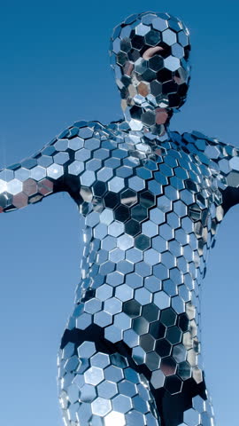 a dancer performs wearing an incredible disco mirror suit that sparkles in the light in vertical format