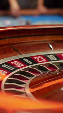 Vertical Screen: Spinning Roulette Wheel with a Ball Stopping at Number Twenty Seven Red. Casino, Gambling, Betting, Winning and Nightlife Concept. Cinematic Zoom In Close Up Footage Royalty-Free Stock Footage #3444312885