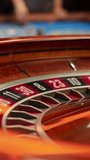 Vertical Screen: Spinning Roulette Wheel with a Ball Stopping at Number Twenty Seven Red. Casino, Gambling, Betting, Winning and Nightlife Concept. Cinematic Zoom In Close Up Footage