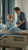 Vertical Screen. Hospital Ward: Handsome Young Boy Resting in Bed with Caring Mother, Friendly Head Nurse Listens to His Lungs, Heart Beat with Stethoscope. Doctor Does Checkup Patient Recovering