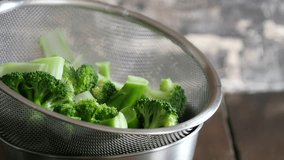 A video of boiled broccoli with a bright green color. Hot steam is coming out.