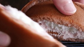 A close-up video of dorayaki sandwiched between whipped cream and strawberry cream.