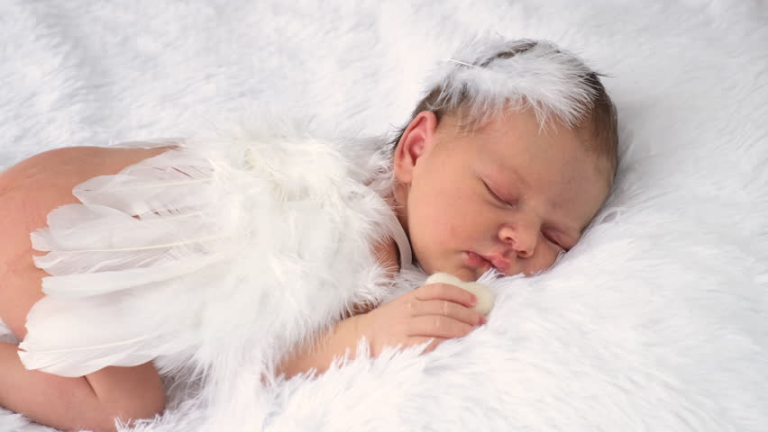 baby with angel wings sleeps on the bed. selective focus.