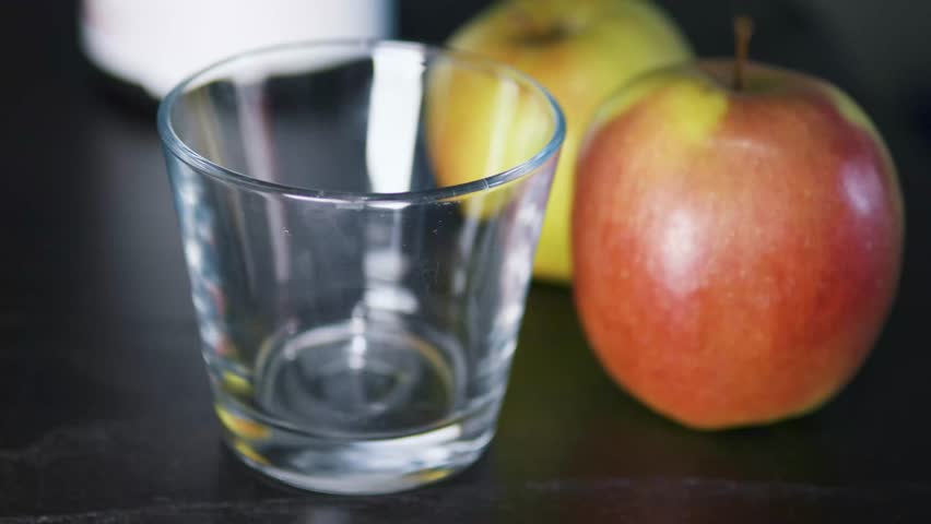 Pouring thick greek yoghurt oatmeal and apple smoothie into glass. Close up.