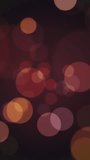 Vertical video - retro bokeh spheres background in warm vintage brown, beige and orange colors. Full HD and looping light effect abstract motion background animation.