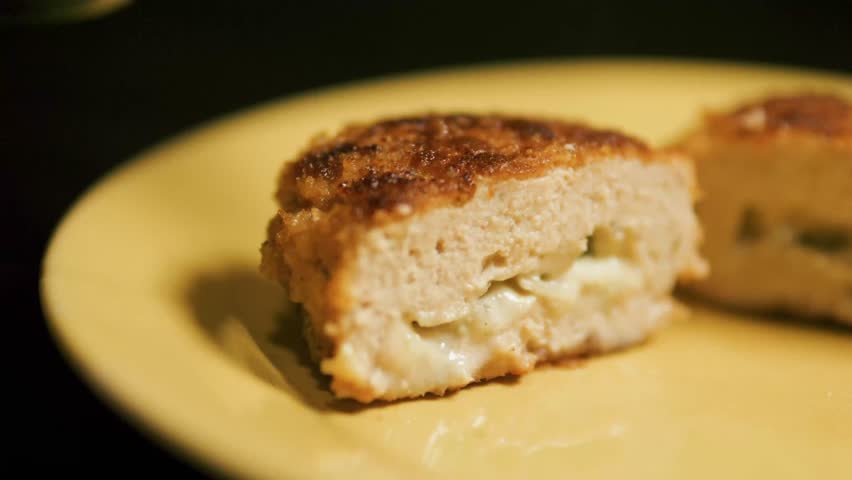 Cutting chicken Cordon Bleu cutlet with cheese inside with knife and fork. Royalty-Free Stock Footage #3444508585