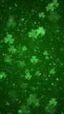 Vertical video - lucky shamrocks, shiny stars and glowing glittering particles on a dark green background. This Saint Patrick's Day celebration party background animation is full HD and looping.