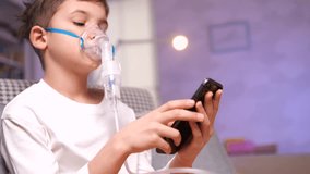 boy plays video games on phone during medical procedure with nebulizer, inhaler