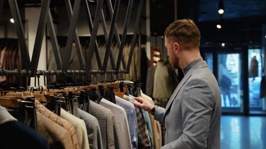 Handsome man shopping for new clothes in luxury store