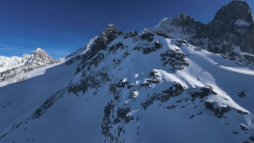 Aerial view of snow mountain peak in french alps on a sunny day, clear blue sky, Mont Blanc, Chamonix
