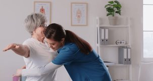 Young female nurse or caregiver measure waist with measuring tape for a senior elderly woman patient standing in medical clinic during examination. Health care in retirement concept. 4k video.