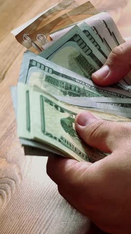 close-up of male hands counting a stack of hundred-dollar US banknotes. a businessman is counting cash. the concept of investment, money exchange, bribes or corruption. selective focus. High quality 4