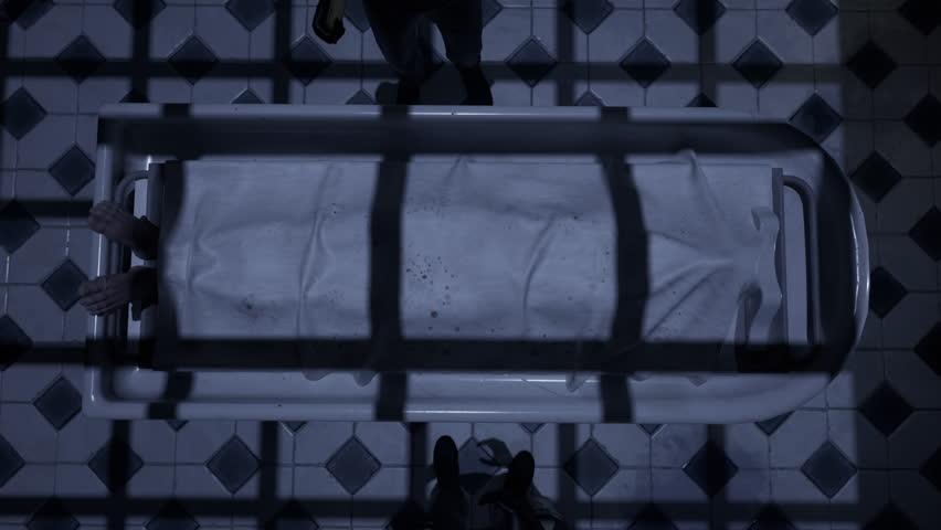 Two doctors standing in fron of a corpse in the morgue and ready to execute an autopsy