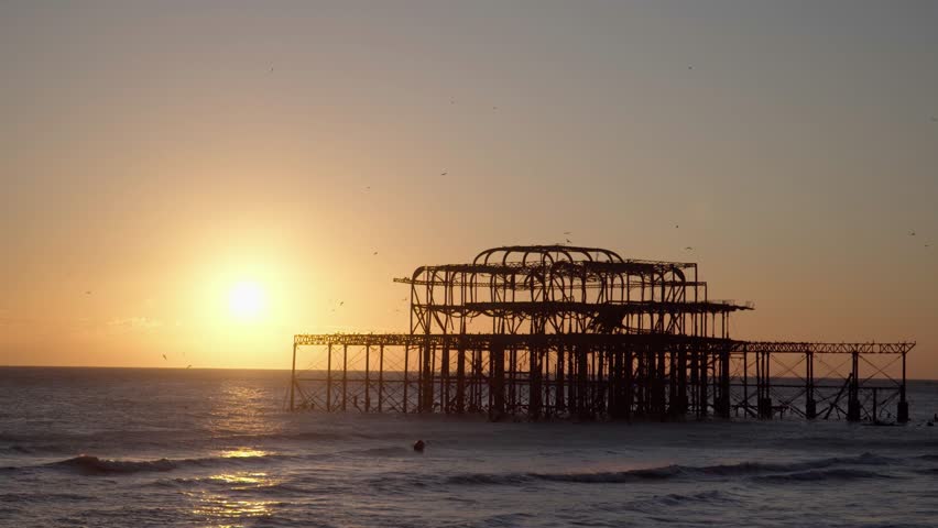 West Pier, Brighton, Silhouetted at Sunset with Birds Flying Around Royalty-Free Stock Footage #3444682121