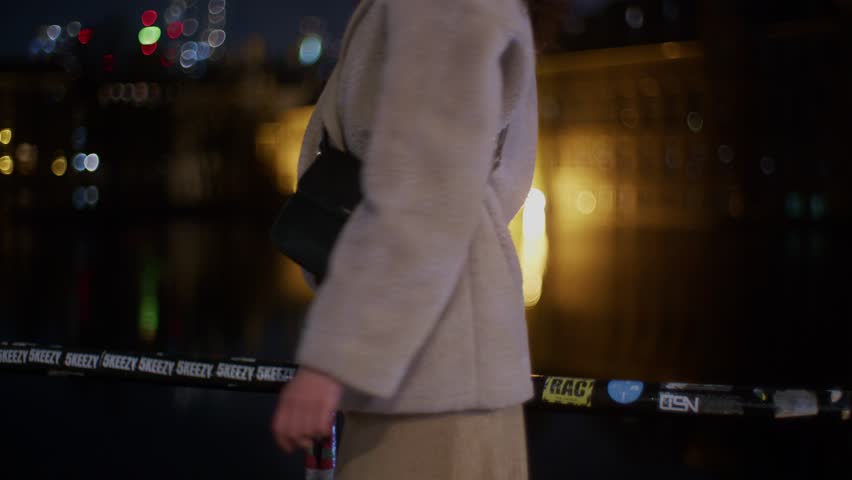 a young beautiful brunette caucasian european white female model woman girl turns around and poses on camera in the night time outdoors