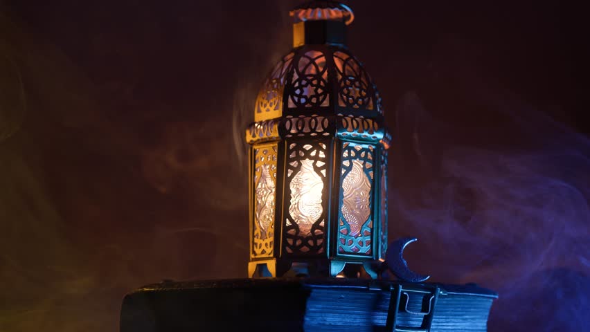 Ornamental Arabic lantern with burning candle glowing at night.Festive greeting card, invitation for Muslim holy month Ramadan Kareem. Royalty-Free Stock Footage #3444723813