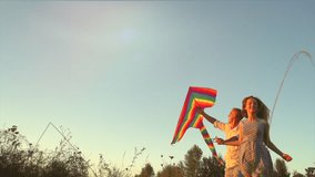 Beauty young couple running with kite on the field. Beautiful family with flying colorful kite over clear sky. Free, freedom concept. Emotions, healthy lifestyle. Slow motion 240 fps 4K UHD video