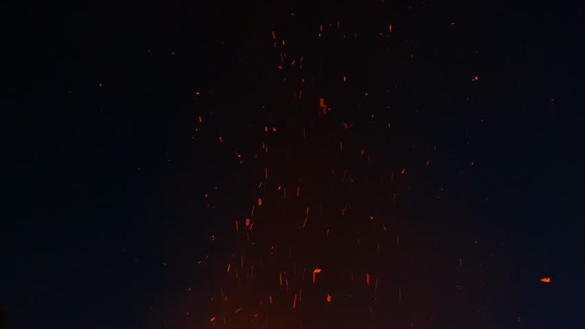 cinders on black background with some flames