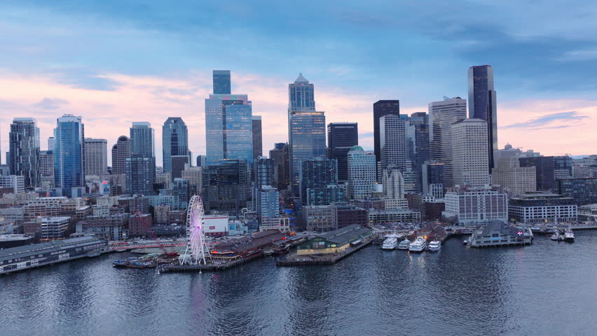Downtown skyscrapers on cinematic background. Financial and residential buildings cityscape view on overcast day 4K. Seattle Washington USA aerial drone footage of Waterfront park with Great Wheel