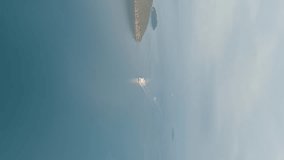 Vertical video. Igoumenitsa, Greece. Large ferry enters the port, Aerial View, Departure of the camera