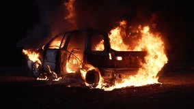 Car burning in flames after a crash at night. High quality 4k footage