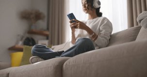 Girl relaxes on her day off, listening to music on headphones. It is serene and joyful morning, bringing feeling of satisfaction and peace. Music fills her with happiness, creating positive mood. AD.